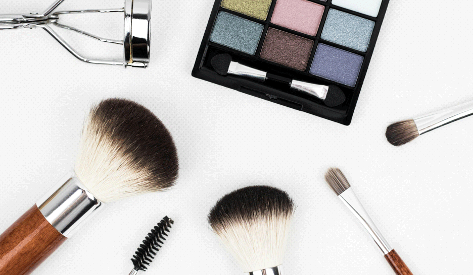 Make-up-Pinsel, Mascara-Pinsel und Farbpalette zur Veranschaulichung, wie man einen Make-up-Fleck aus der Kleidung entfernt